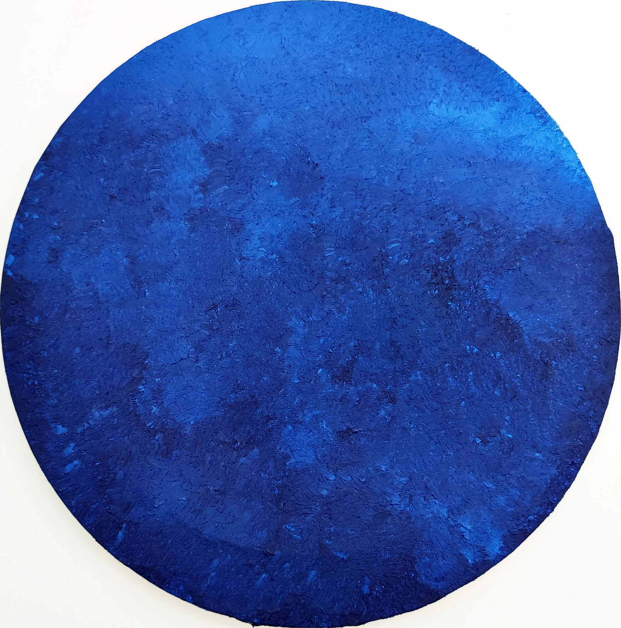 A circular field of cobalt blue, punctuated by a dense, tactile surface.